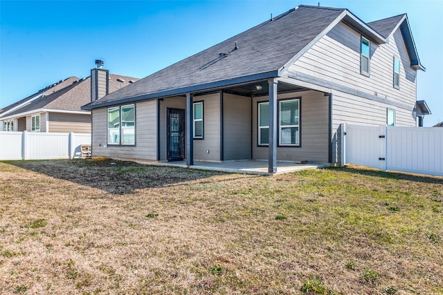 rear view of house with a yard and a patio