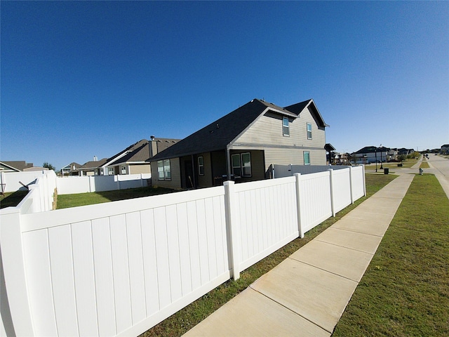 view of side of home with a yard