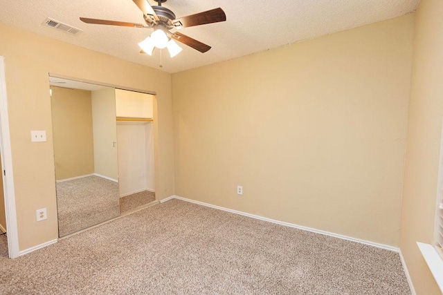 unfurnished bedroom featuring ceiling fan, carpet, a closet, and a textured ceiling