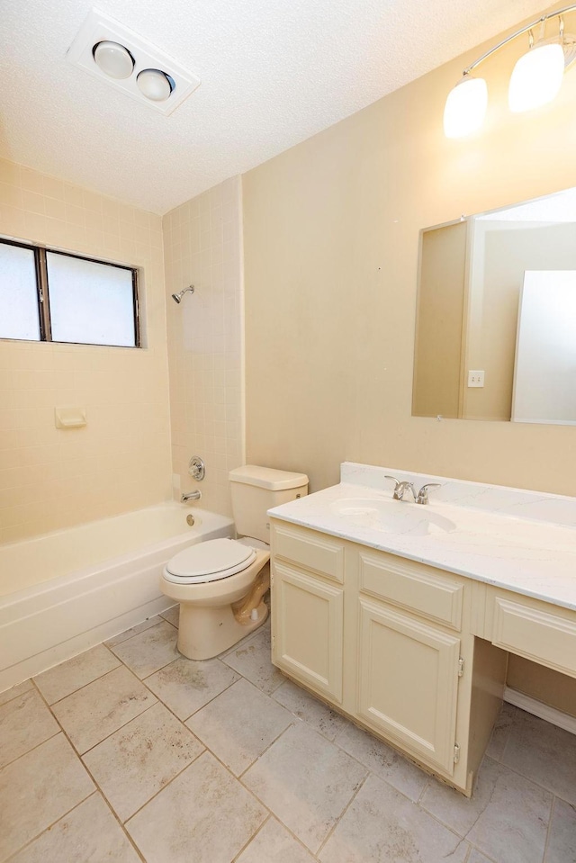 full bathroom featuring tiled shower / bath combo, toilet, and vanity