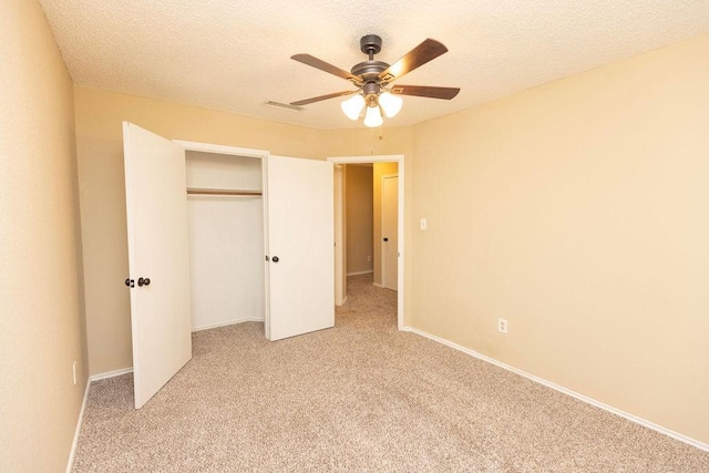 unfurnished bedroom featuring a closet, ceiling fan, a textured ceiling, and carpet floors