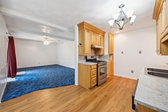 kitchen with sink, hanging light fixtures, stainless steel range with gas stovetop, light hardwood / wood-style floors, and decorative backsplash