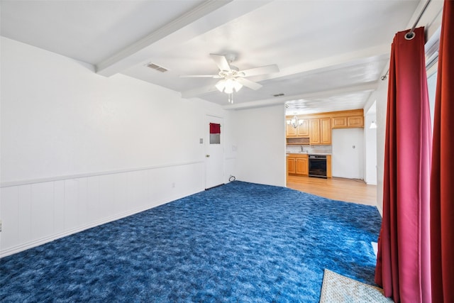 unfurnished living room featuring beamed ceiling, ceiling fan, beverage cooler, and light colored carpet