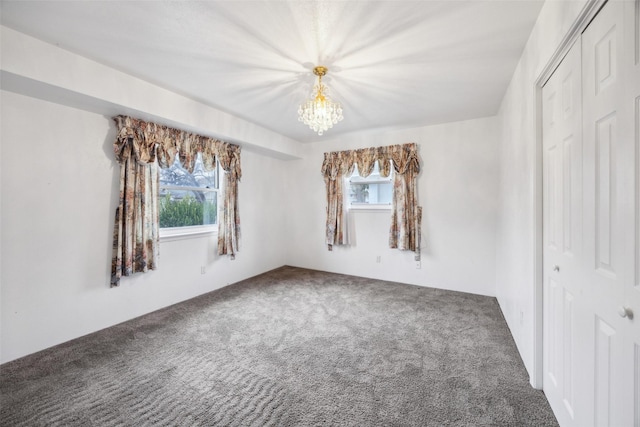 unfurnished room with carpet, a wealth of natural light, and a chandelier