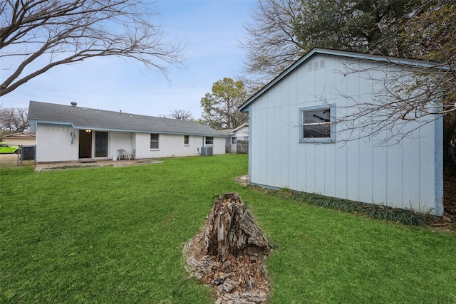 back of house with central AC and a lawn