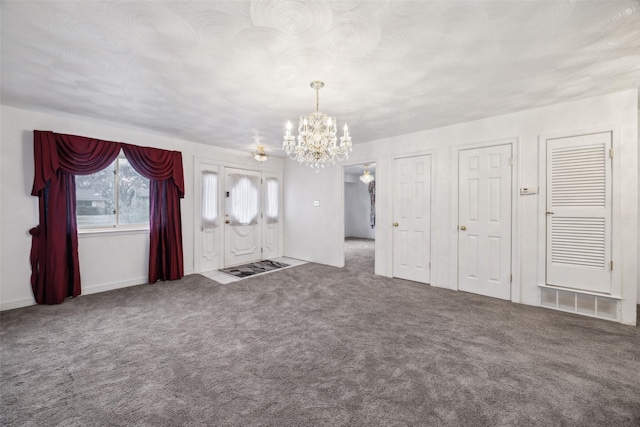 unfurnished living room with an inviting chandelier and carpet flooring