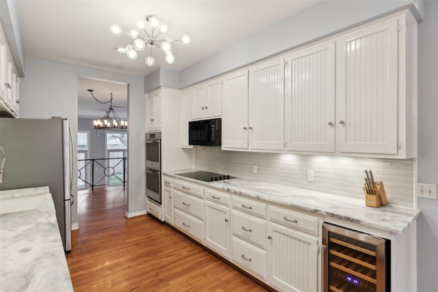 kitchen featuring black appliances, an inviting chandelier, white cabinets, and wine cooler