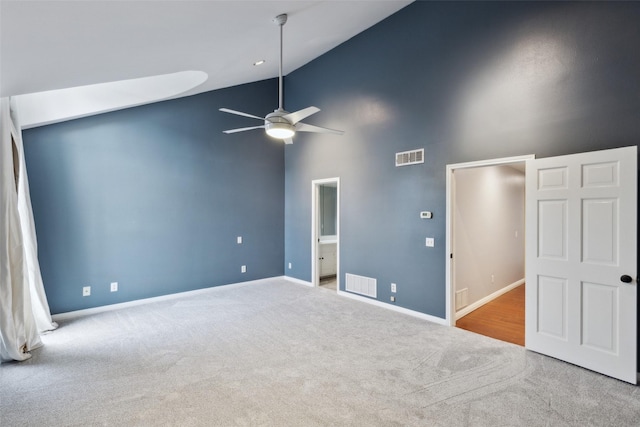 interior space featuring ceiling fan, high vaulted ceiling, and light colored carpet