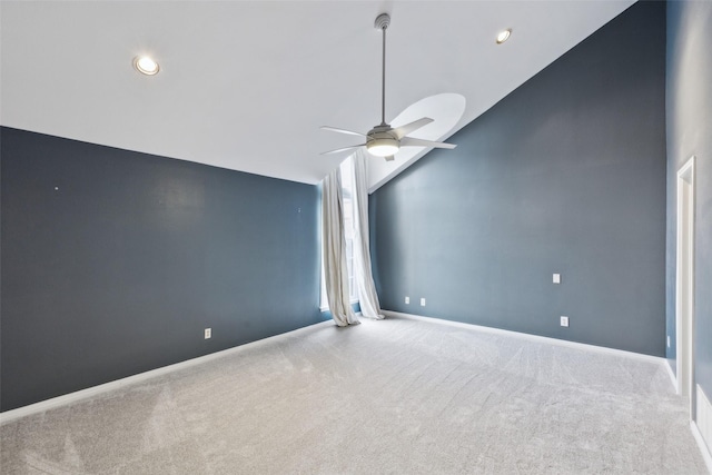 carpeted spare room with vaulted ceiling and ceiling fan