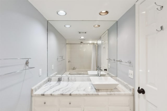 bathroom featuring vanity and tiled shower / bath