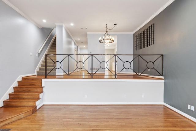 staircase with hardwood / wood-style floors, crown molding, and a chandelier