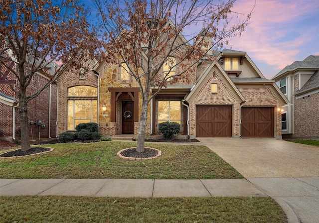 view of front of property with a garage and a lawn