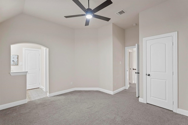 carpeted spare room featuring ceiling fan and lofted ceiling