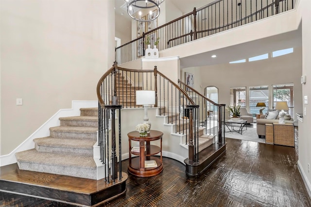 stairs with a high ceiling and wood-type flooring