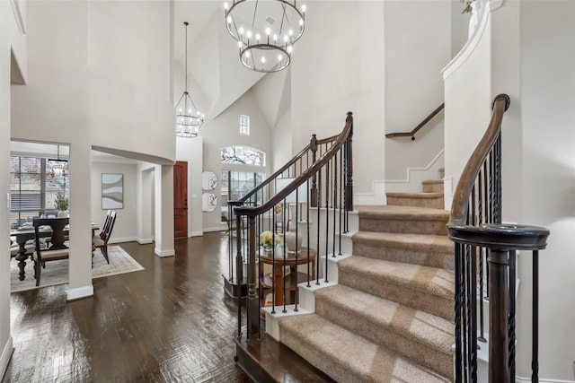 entrance foyer featuring a high ceiling, dark hardwood / wood-style floors, and an inviting chandelier