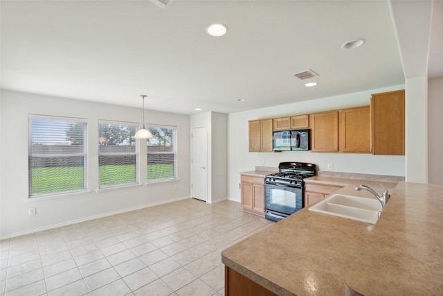 kitchen with kitchen peninsula, pendant lighting, sink, light tile patterned floors, and black appliances