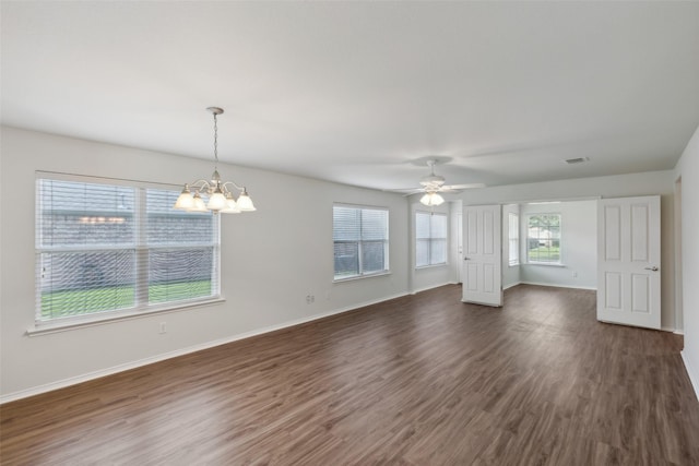 unfurnished living room with ceiling fan with notable chandelier and dark hardwood / wood-style flooring