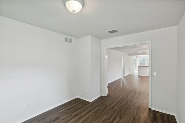 unfurnished room with dark wood-type flooring