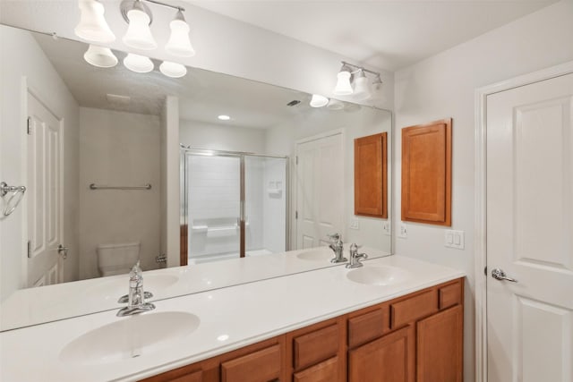 bathroom with a shower with door, toilet, and vanity