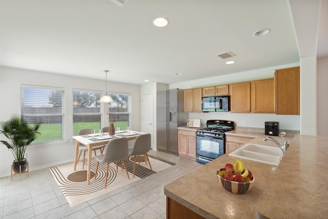 kitchen featuring pendant lighting, black appliances, sink, kitchen peninsula, and light tile patterned floors