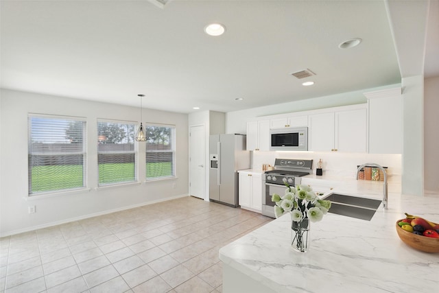 kitchen featuring decorative light fixtures, sink, white cabinets, and appliances with stainless steel finishes