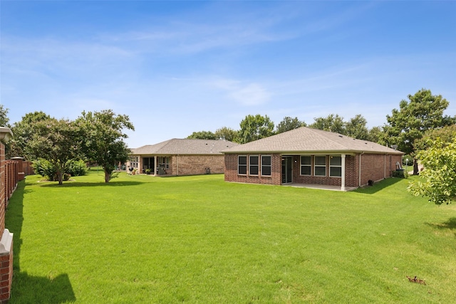 rear view of property featuring a lawn