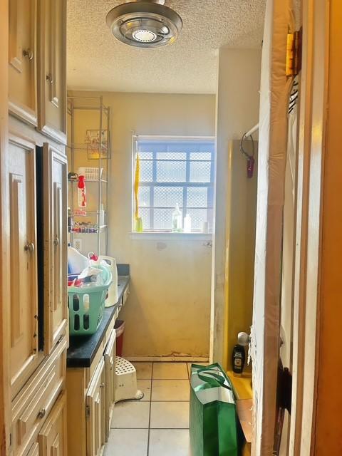 bathroom featuring a textured ceiling, tile patterned flooring, and vanity