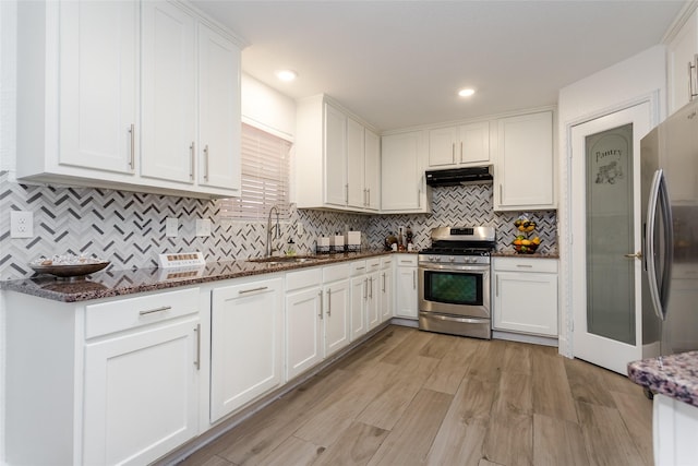 kitchen featuring sink, white cabinets, dark stone countertops, and stainless steel appliances