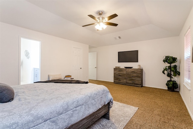 carpeted bedroom featuring ceiling fan and a tray ceiling