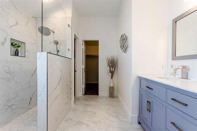 bathroom featuring tiled shower and vanity