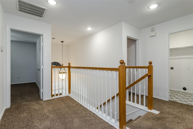 hall with dark colored carpet