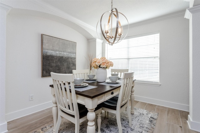 dining space with crown molding and a chandelier