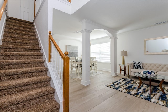 interior space with crown molding and decorative columns