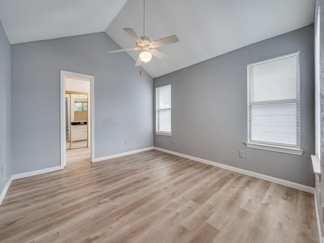 empty room featuring ceiling fan, plenty of natural light, light wood-type flooring, and lofted ceiling