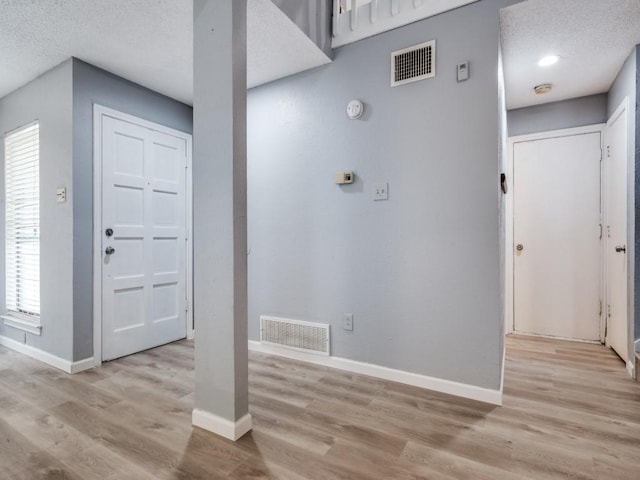 entryway featuring light hardwood / wood-style floors and a textured ceiling