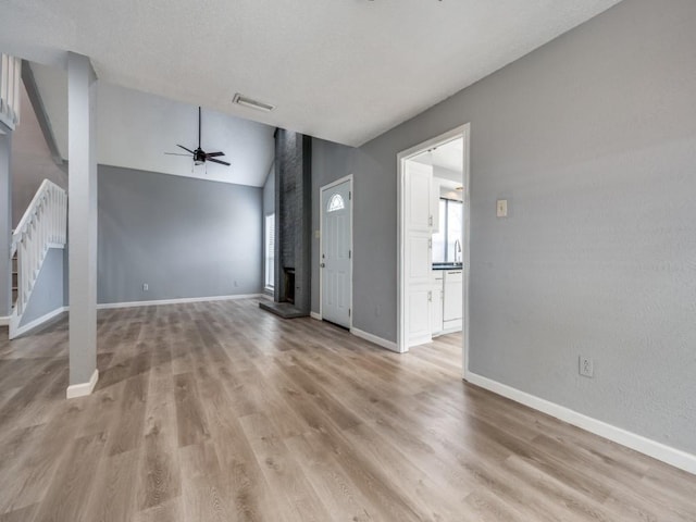 unfurnished living room with sink, vaulted ceiling, ceiling fan, and light hardwood / wood-style floors