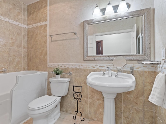 bathroom with toilet, tile patterned flooring, and tile walls