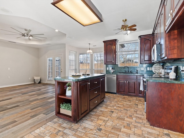 kitchen with sink, decorative light fixtures, a center island, appliances with stainless steel finishes, and ceiling fan