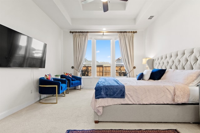 bedroom with ceiling fan, a tray ceiling, and carpet floors