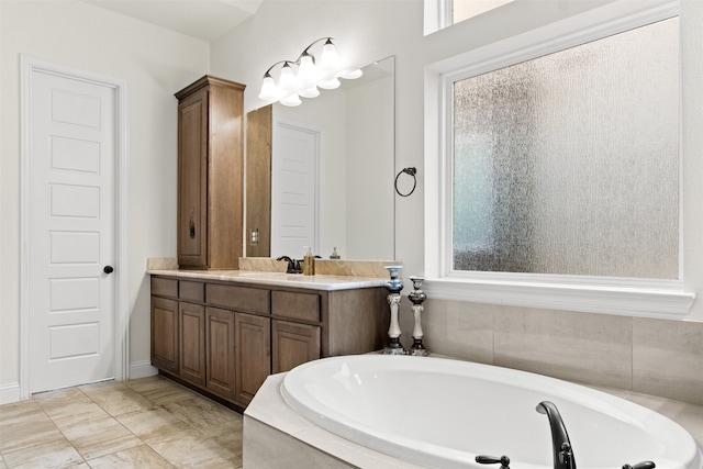 bathroom featuring tiled bath and vanity