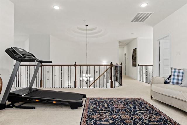 exercise room featuring carpet flooring and a notable chandelier