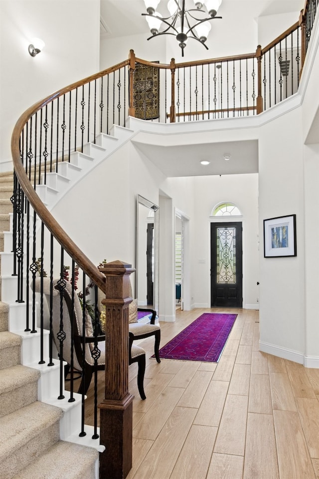 foyer entrance featuring a towering ceiling and a notable chandelier