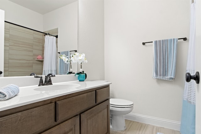 bathroom featuring toilet, vanity, and a shower with curtain