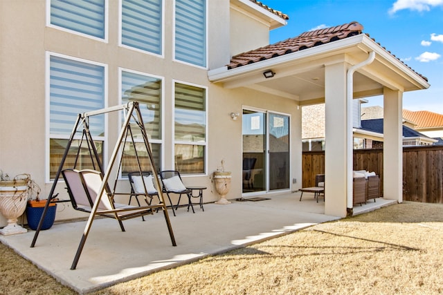 rear view of property with an outdoor living space and a patio