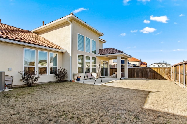 rear view of house with a patio area, a yard, and central AC unit