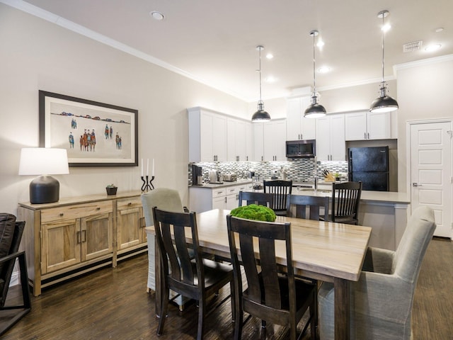 dining room with ornamental molding and dark hardwood / wood-style flooring