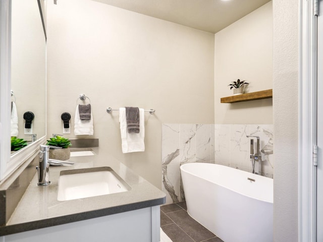 bathroom featuring a bath, tile patterned flooring, tile walls, and vanity