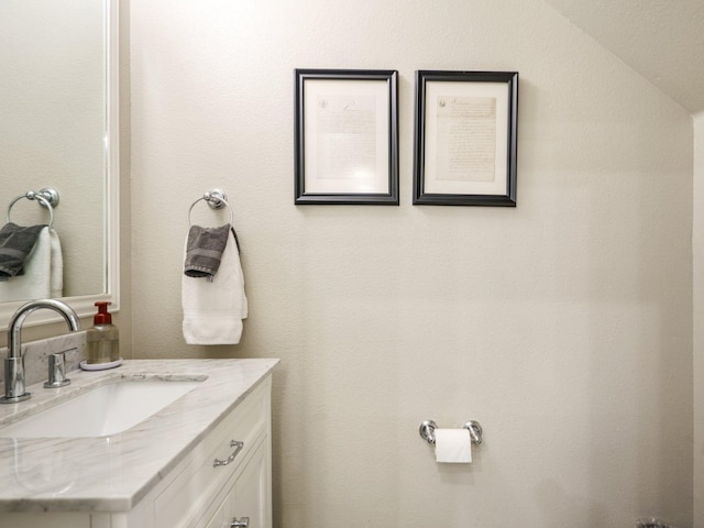 bathroom with vanity and vaulted ceiling