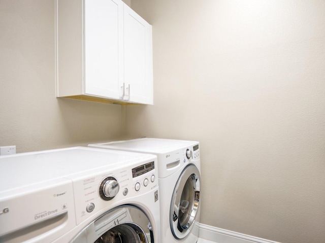 laundry area featuring washing machine and dryer and cabinets