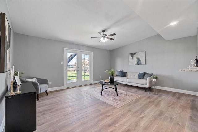 living room with light hardwood / wood-style floors, ceiling fan, and french doors